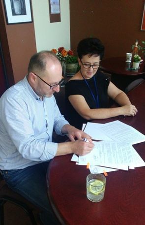 podpisanie umowy. na zdjęciu przedstawiciel stowarzyszenia oraz Główny Specjalista wydziału administracji budowlanej p. Bożena Szałkowska